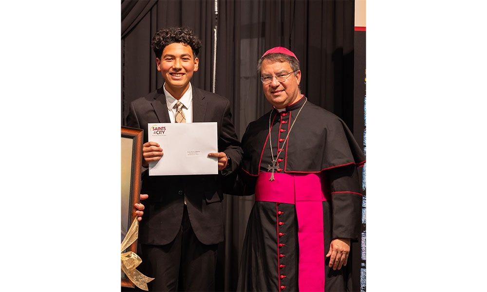 Student stands with Bishop Cantú