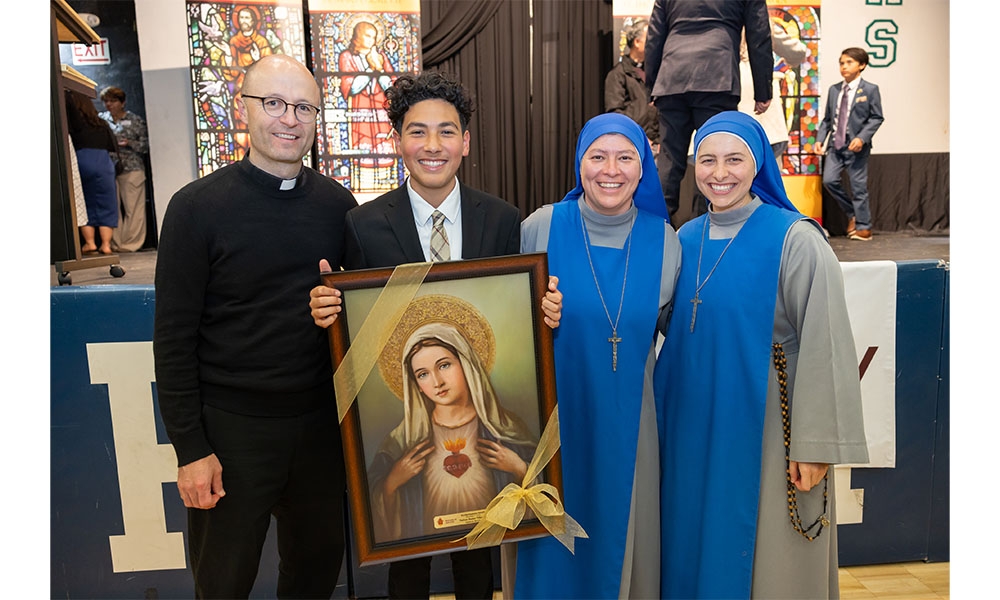 Student stands with pastor and religious sisters