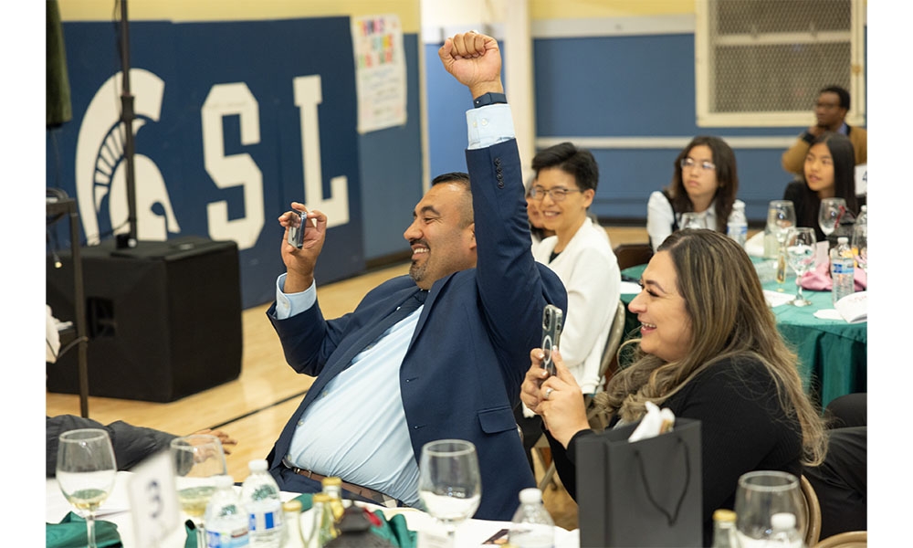 Parents sit at table taking photos of son