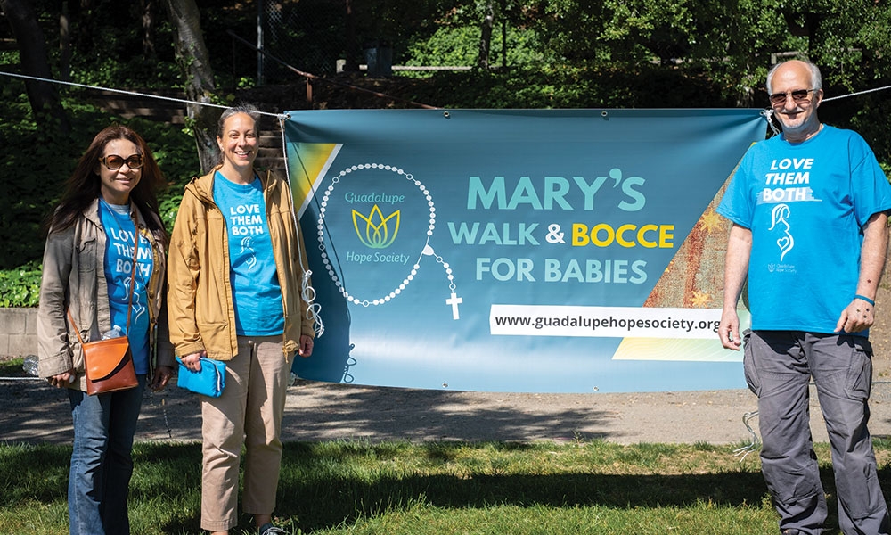 Michael Shirley and Walkers standing in front of Mary's Walk for Babies Banner