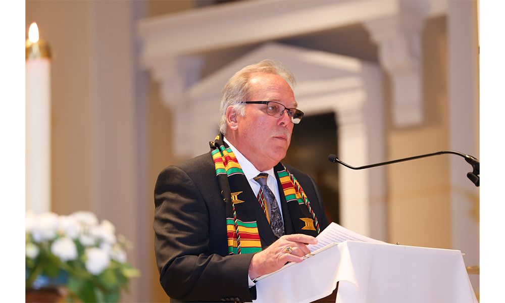 Mike Ruppert stands at podium delivering his speech