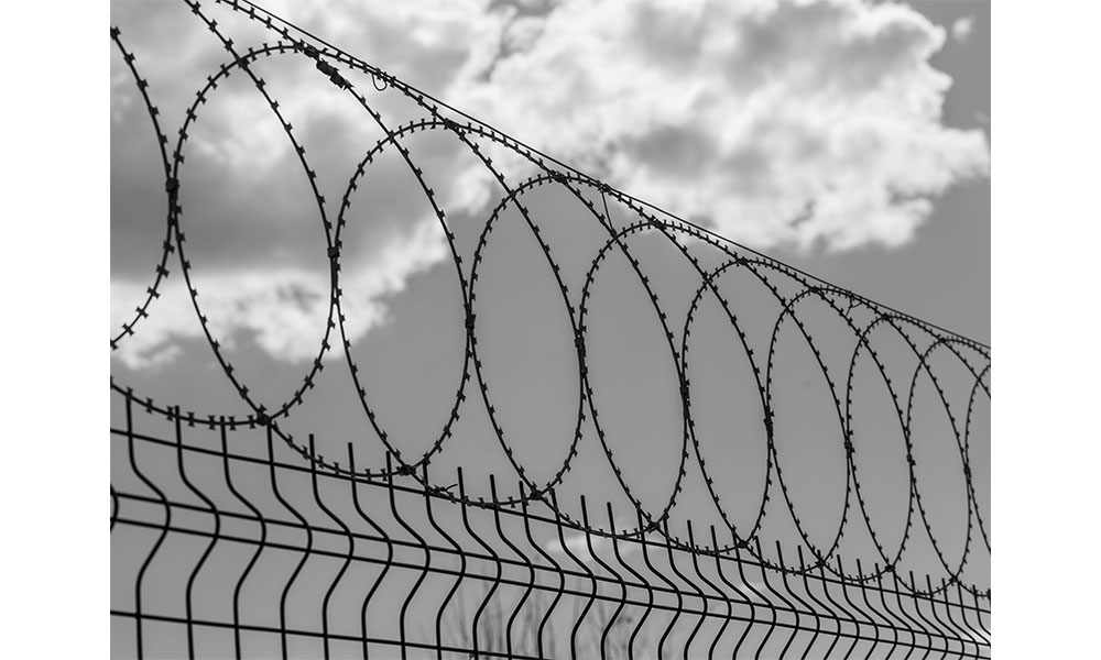 Barbed wire against the backdrop of a sky with clouds